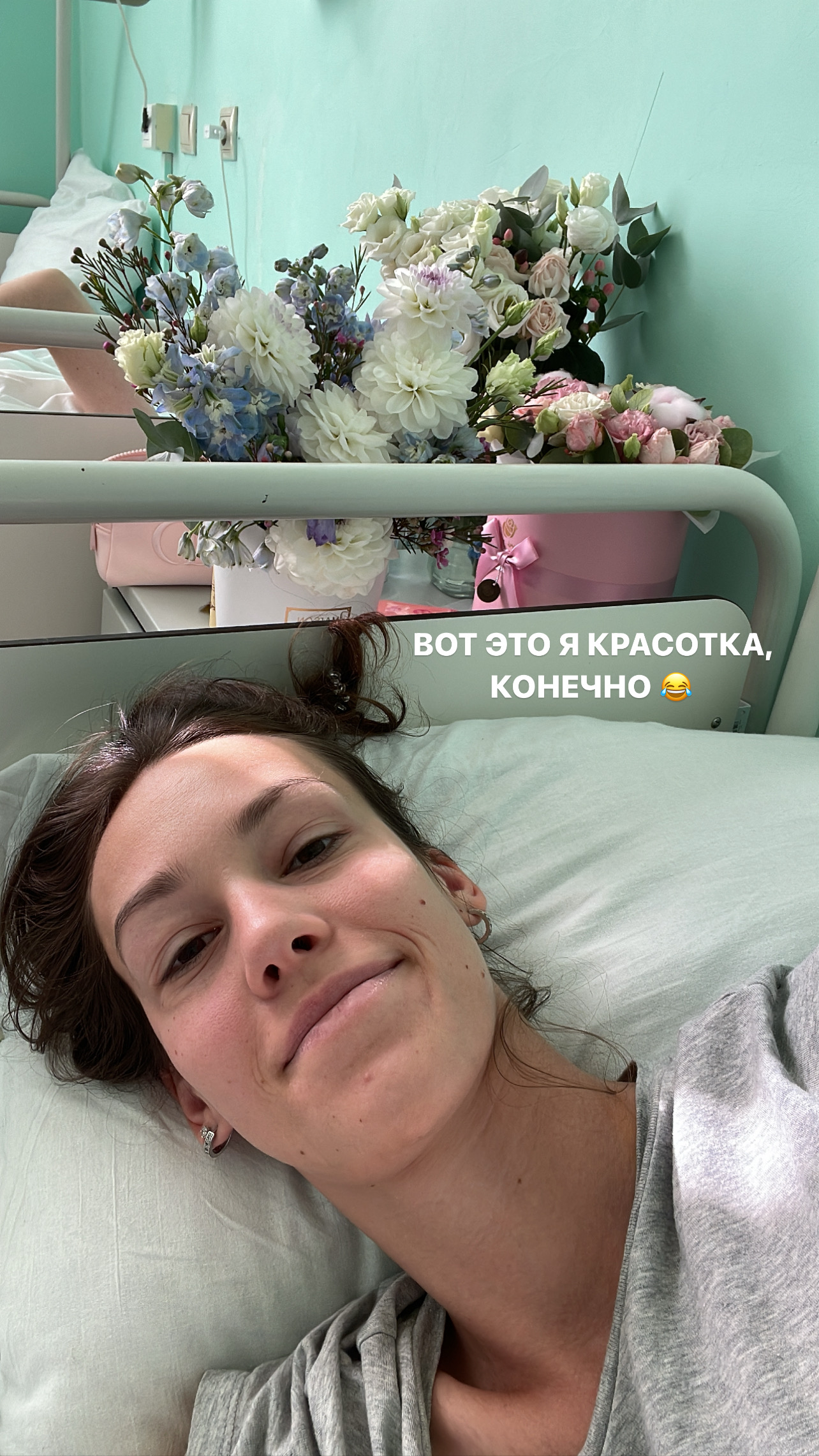 Даша в больничной палате после операции, рядом букеты цветов